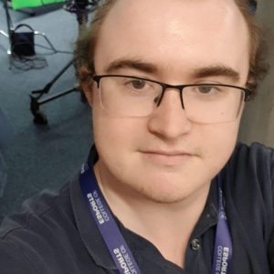 ʼһ esports student Charles Thompson, a male wearing glasses and a black polo top.